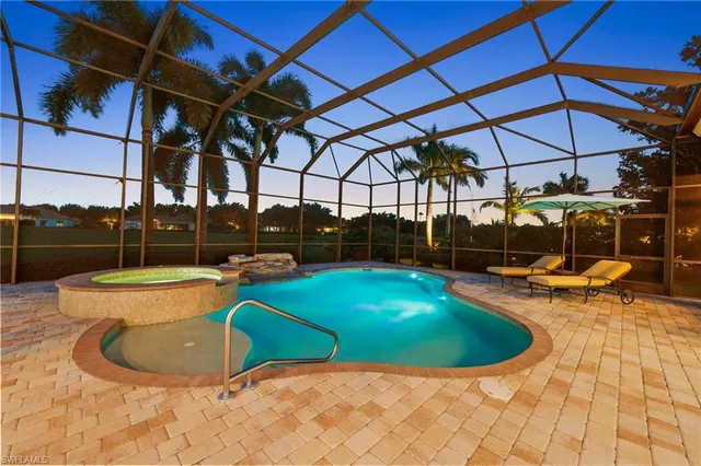 a view of a swimming pool with a bench in front of house