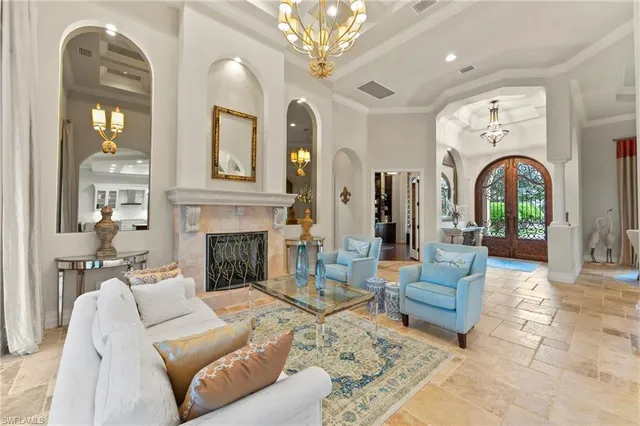 a living room with furniture a fireplace and a chandelier