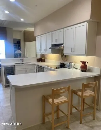 a kitchen with stainless steel appliances a sink a stove a table and chairs