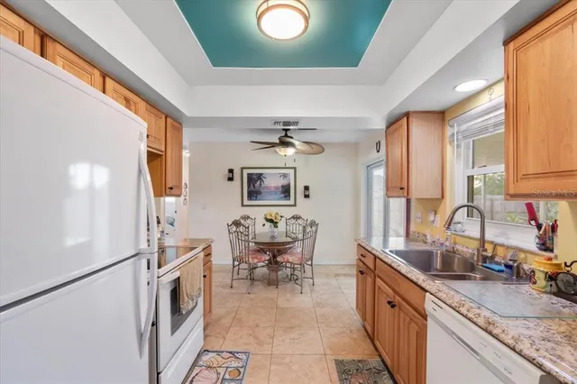 a kitchen with stainless steel appliances granite countertop a sink dishwasher a stove a refrigerator and island with wooden floor