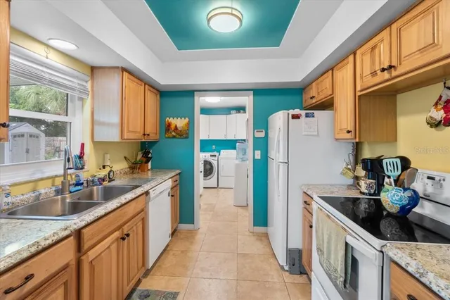 a kitchen with a sink refrigerator and cabinets