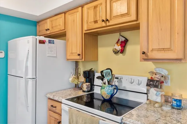 a kitchen with stainless steel appliances granite countertop a refrigerator a sink and a stove