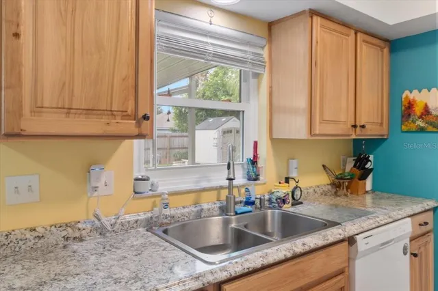 a kitchen with a sink cabinets and a window