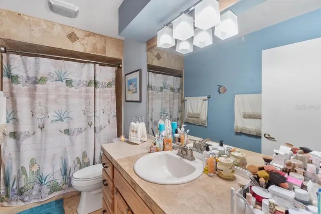 a bathroom with a sink a toilet and shower curtain