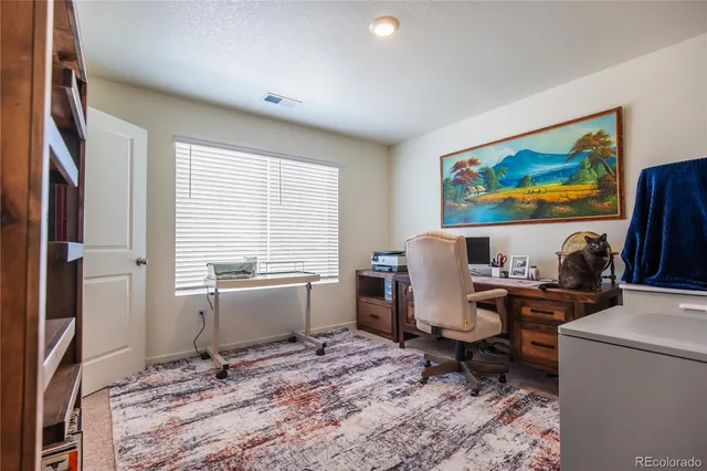 a view of a workspace with furniture and window