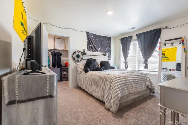 a bedroom with a bed dresser and a window