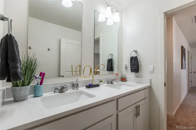 a bathroom with double vanity a mirror and a sink