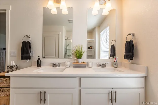 a bathroom with double vanity sinks and a mirror