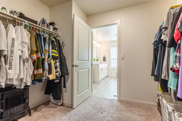 a view of walk in closet with clothes and shoes