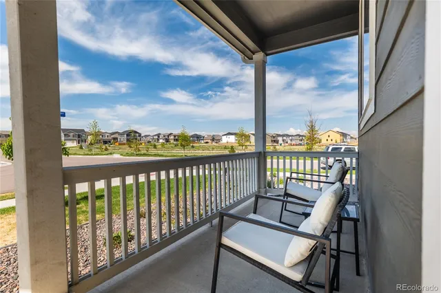 a view of a balcony with wooden chairs