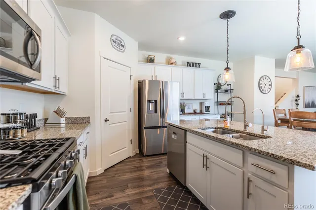 a kitchen with refrigerator a stove and a sink