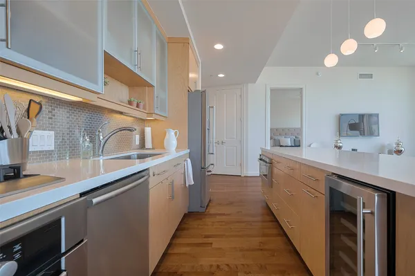 a large kitchen with stainless steel appliances a sink and cabinets