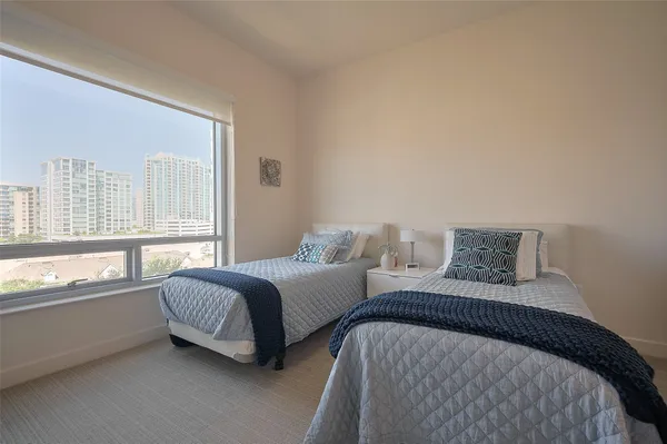a bedroom with two beds and a large window