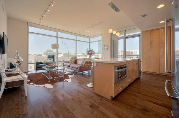 a room with stainless steel appliances a stove a sink a refrigerator and cabinets