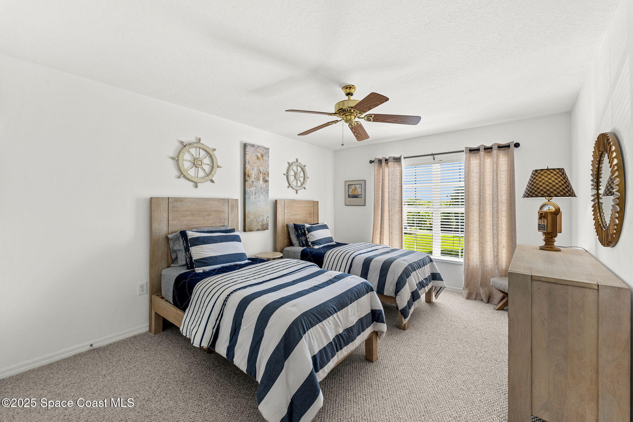 400 Trotter Lane, Unit 204 Melbourne, FL 32940 - Photo 19 of 38 a bedroom with two beds and a chandelier