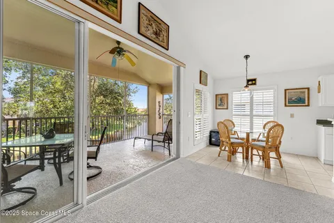 a dining room with furniture water view and a floor to ceiling window