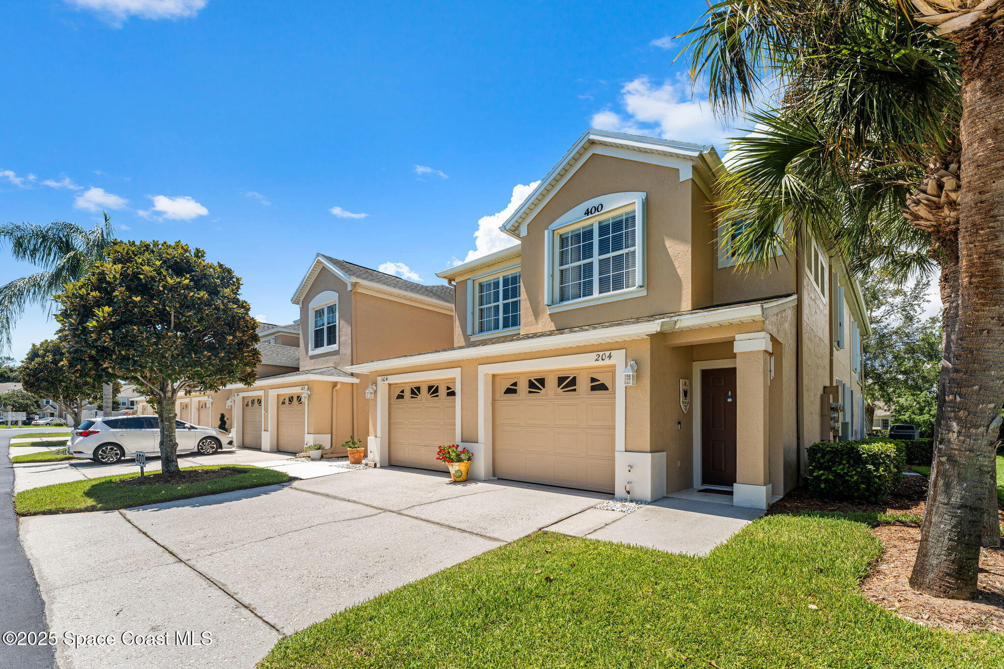 400 Trotter Lane, Unit 204 Melbourne, FL 32940 - Photo 29 of 38 a front view of a house with a yard and garage