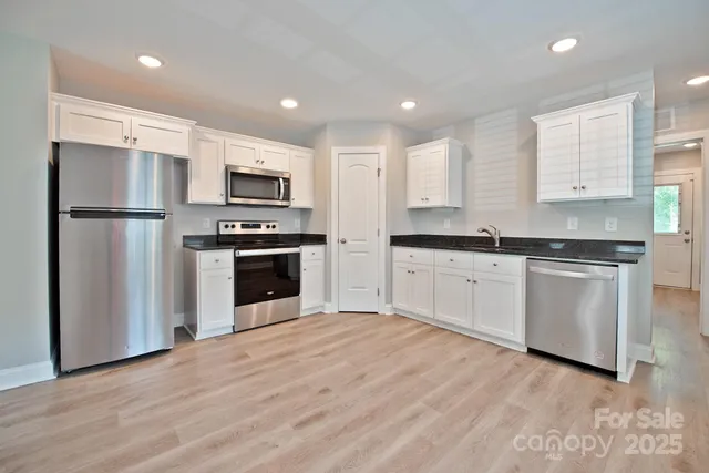 a kitchen with a refrigerator sink and cabinets