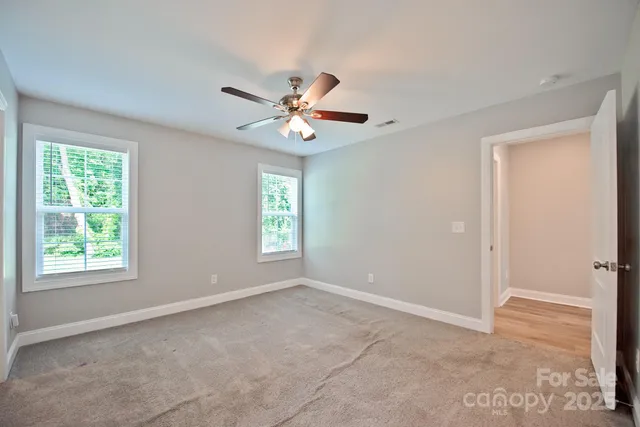 a view of a room with a ceiling fan and a window