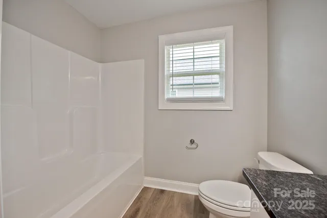 a bathroom with a granite countertop toilet a sink and bathtub