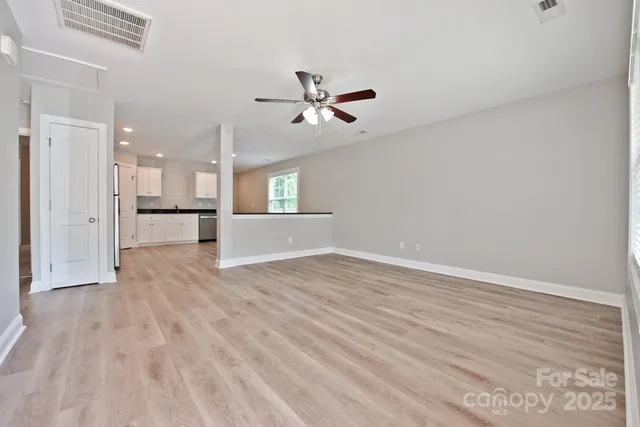 wooden floor in an empty room with a kitchen