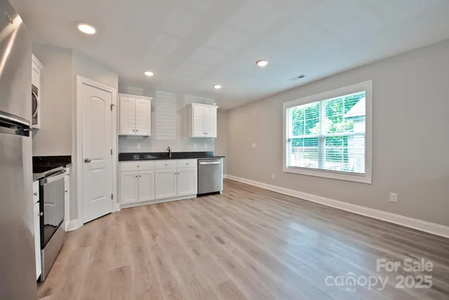 a kitchen with white cabinets and appliances