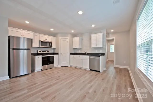 a kitchen with stainless steel appliances granite countertop a refrigerator and a stove top oven
