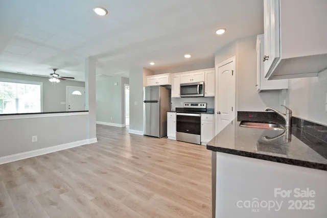 a kitchen with kitchen island a sink stainless steel appliances and cabinets