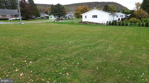 a white house with a big yard and large trees