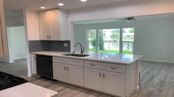a kitchen with white cabinets a sink and a window