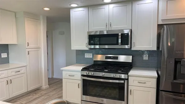 a kitchen with stainless steel appliances a stove a microwave and cabinets