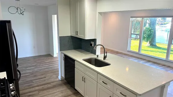 a kitchen with stainless steel appliances granite countertop a sink and a refrigerator