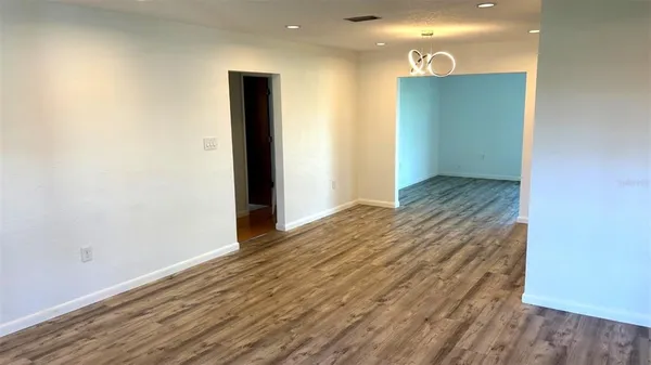 a view of a room with wooden floor and window