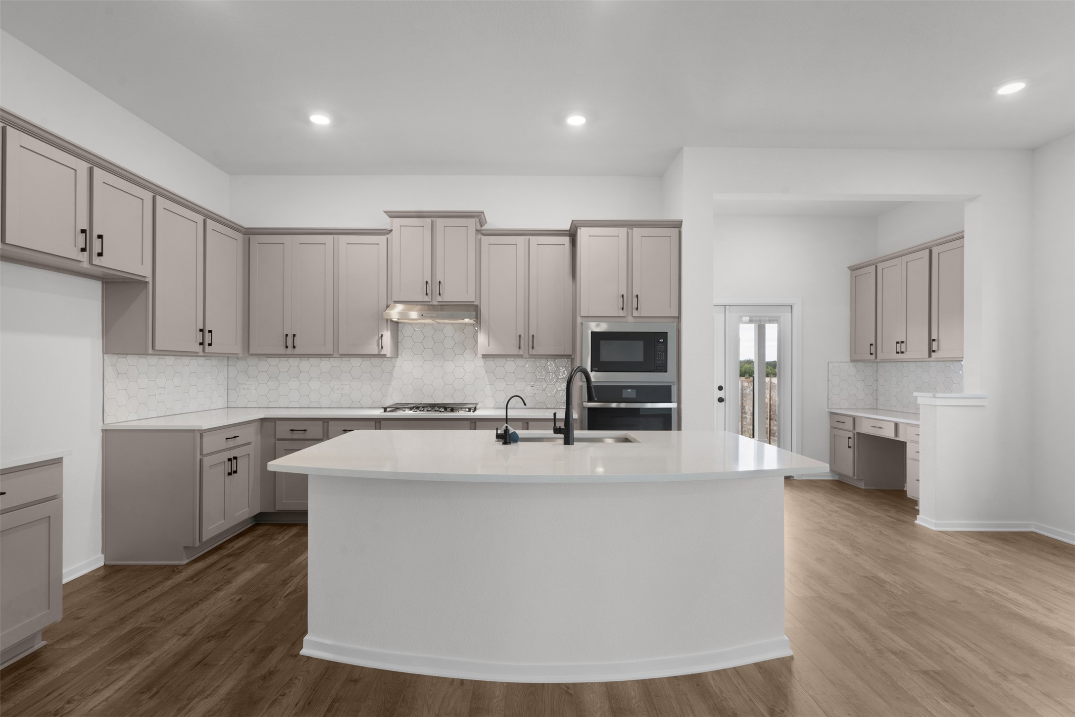 405 Raleigh Drive Georgetown, TX 78633 - Photo 8 of 27 Kitchen featuring tasteful backsplash, a kitchen island with sink, gray cabinetry, dark wood-style floors, and recessed lighting
