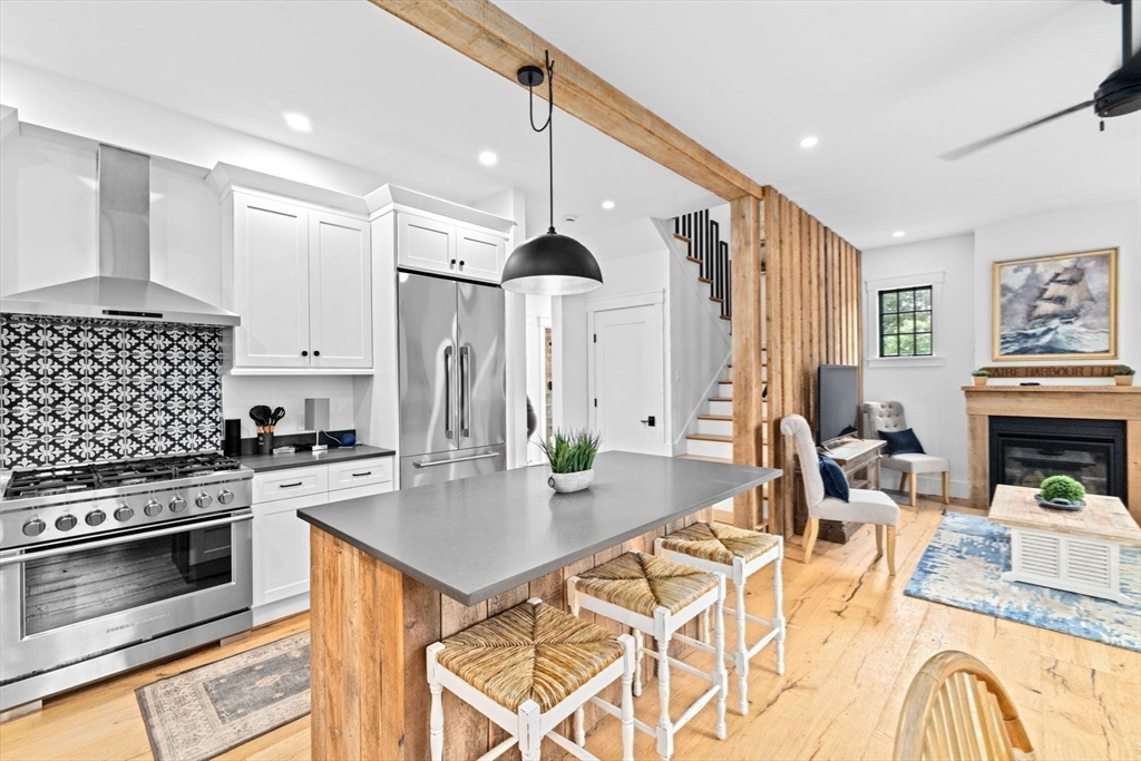 42 Captain Peirce Road Scituate, MA 02066 - Photo 2 of 40 a kitchen with stainless steel appliances kitchen island granite countertop a stove a sink a dining table and chairs with wooden floor