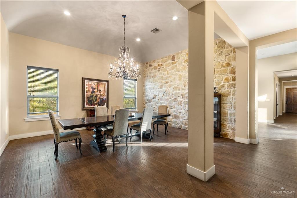 17839 Abd Road Harlingen, TX 78552 - Photo 10 of 38 a dining room with wooden floor a chandelier a glass table and chairs