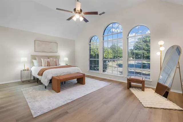 a bedroom with a bed a chandelier and a large window