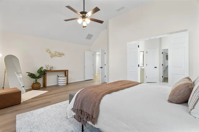 a spacious bedroom with a bed and a chandelier