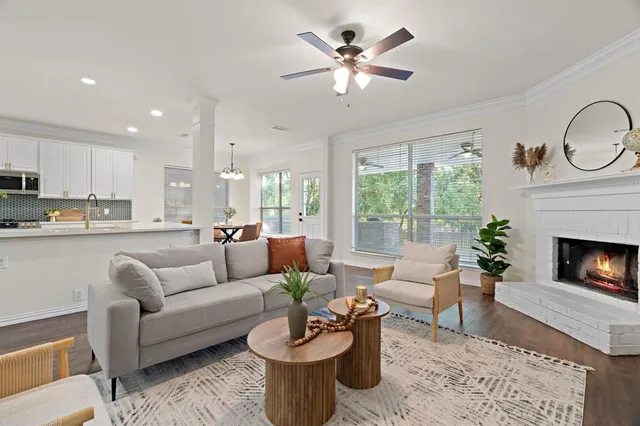a living room with furniture a fireplace and a large window