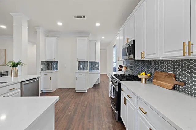 a kitchen with a sink a stove and cabinets
