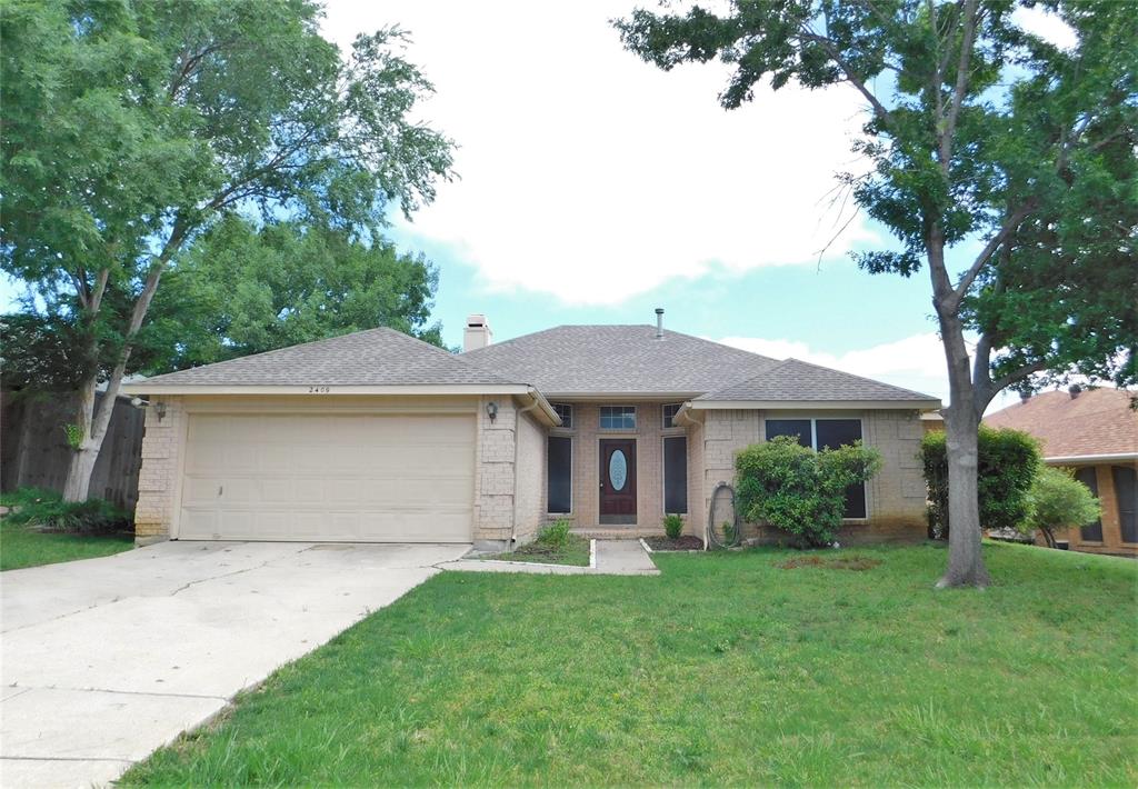 a front view of a house with a garden and yard