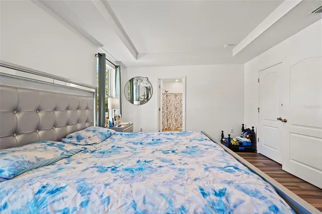 a bedroom with a large bed and a chandelier