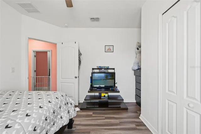 a bedroom with bed and wooden floor