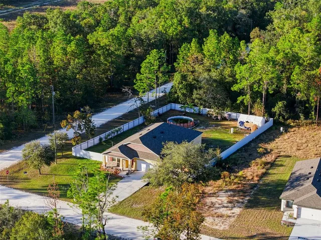 an aerial view of a house with swimming pool garden and patio