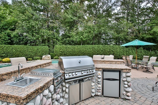 84 Sunset Rock Road Andover, MA 01810 - Photo 8 of 30 a view of a patio with a table and chairs under an umbrella