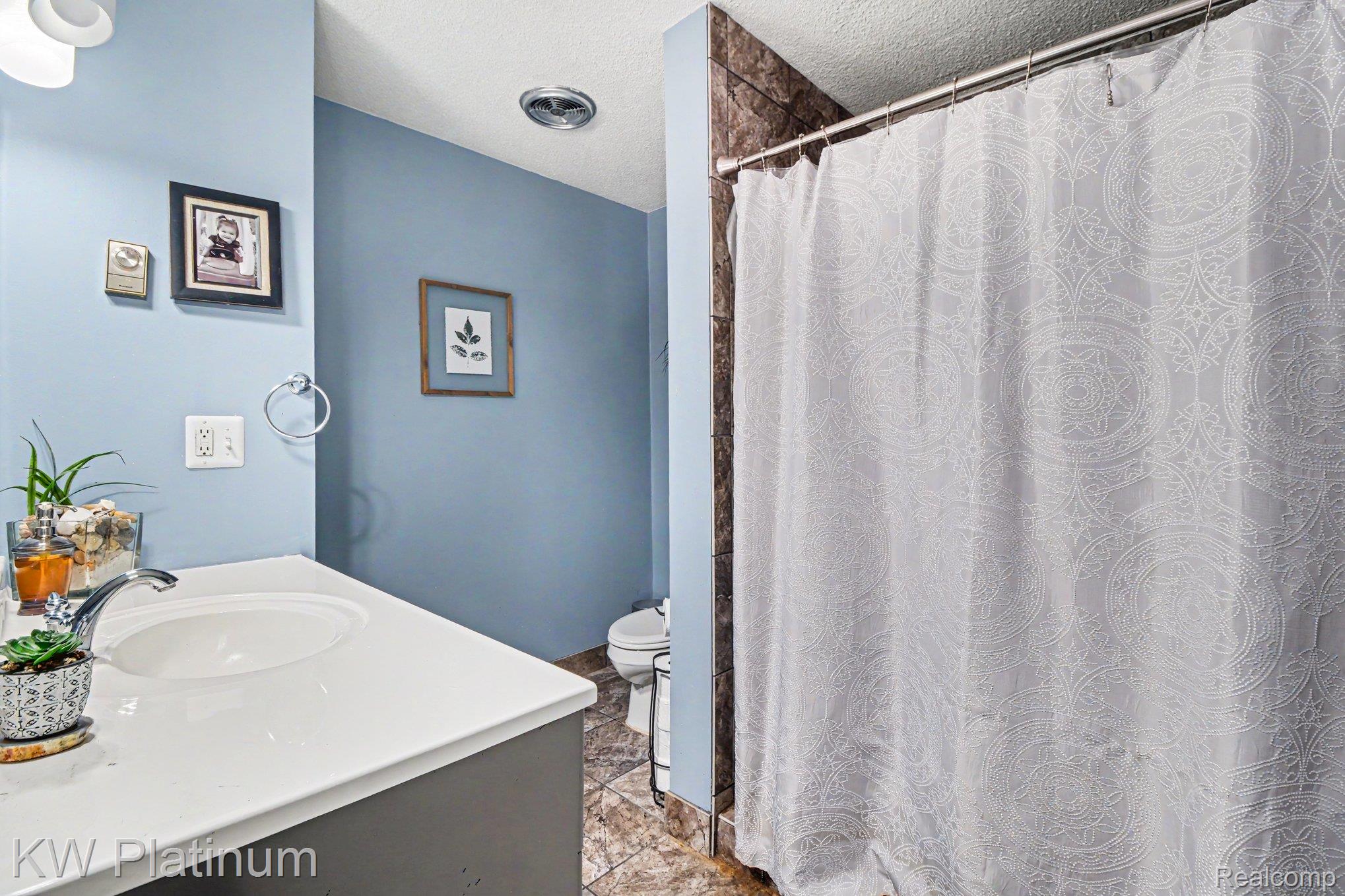 1900 River Road, Unit C5 Marysville, MI 48040 - Photo 12 of 15 Bathroom featuring curtained shower, vanity, and a textured ceiling