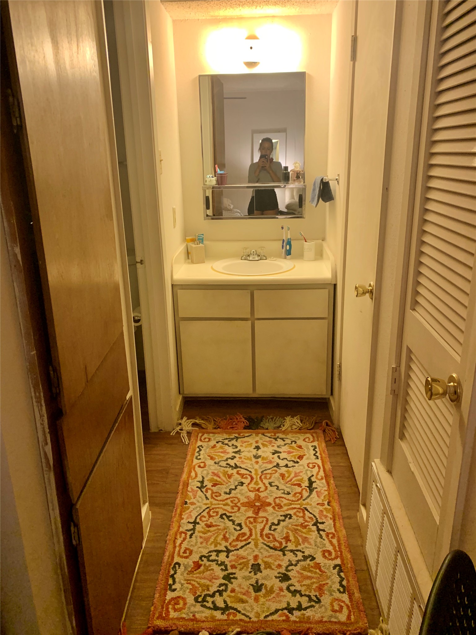 105 East 31st Street, Unit 101 Austin, TX 78705 - Photo 2 of 9 Bathroom with vanity, light wood-type flooring, a textured ceiling, and a closet