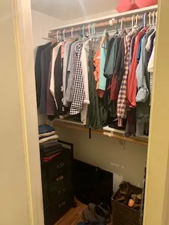a view of walk in closet with clothes and shoes