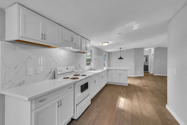 a kitchen with cabinets a sink and wooden floor