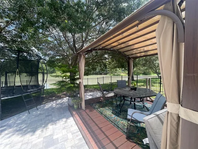 a view of a yard in front of a house with a large tree